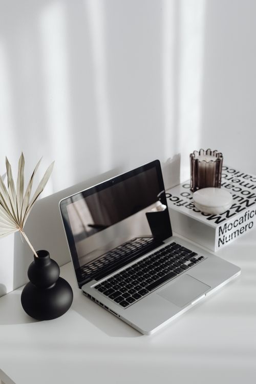 A neat laptop standing on a minimalist wooden desk in a home office setting