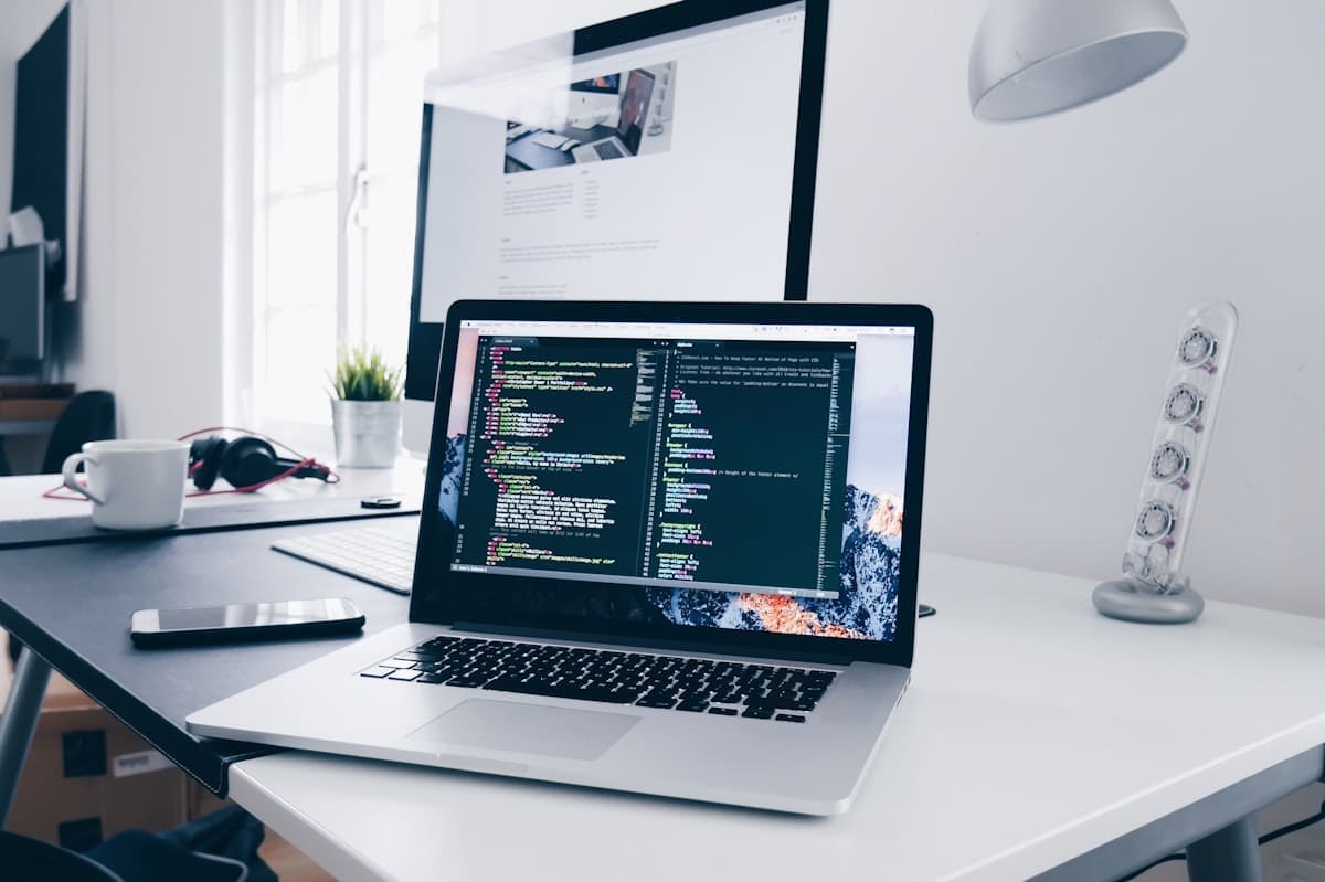 A person working on a laptop at a clean wooden desk, representing remote work