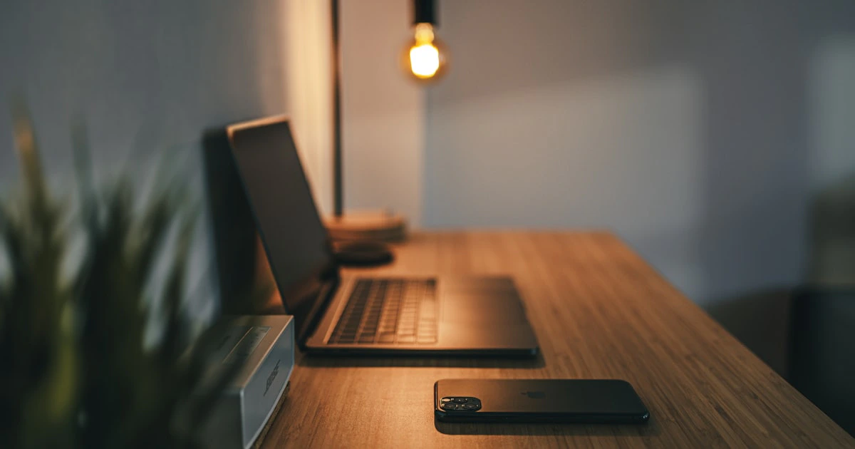 Laptop raised on a stand at eye level on an organized home office desk