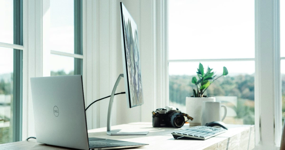Professional dual-monitor desk setup with laptop in a contemporary home office