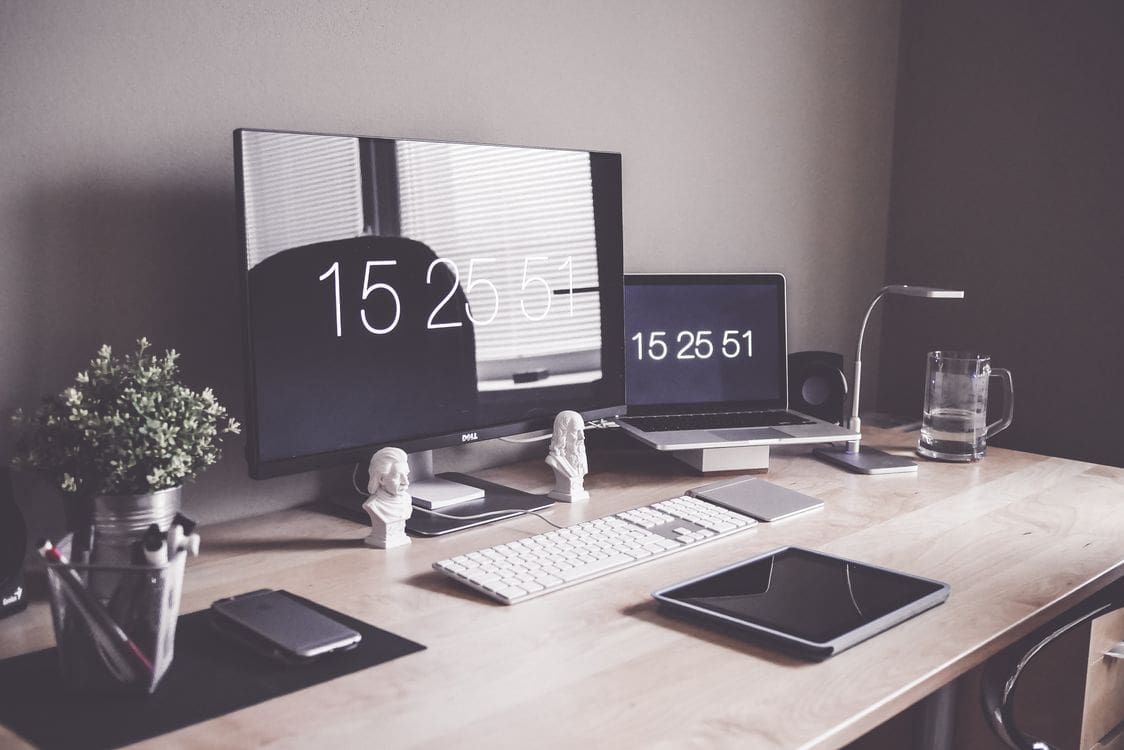 Organized computer desk setup with dual monitors and laptop in a productive home office workspace