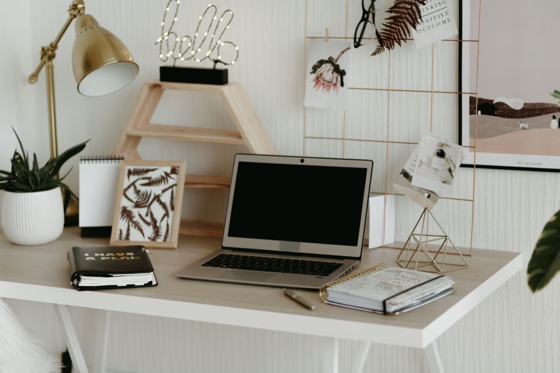 A laptop on a clean wooden desk in a minimalist home office workspace