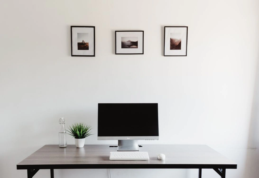 A minimalist workspace with a computer, keyboard and mouse on a clean desk