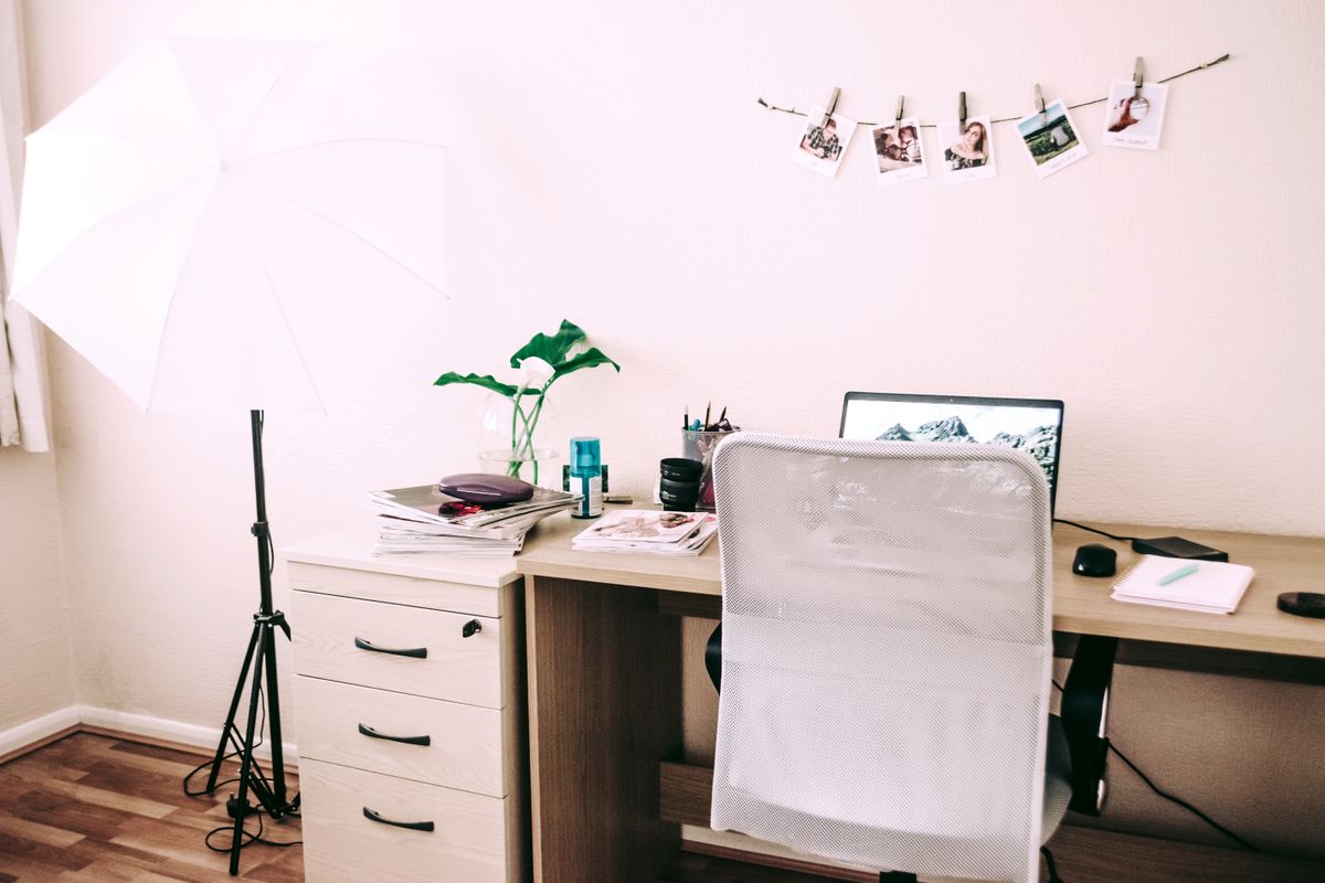 A tidy home office work area with a laptop on a desk and decorative plants