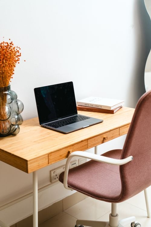 Modern minimalist home office desk setup with laptop and organized accessories